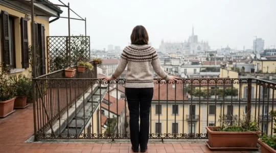 Donna osserva lo skyline di Milano dal balcone di un appartamento residenziale