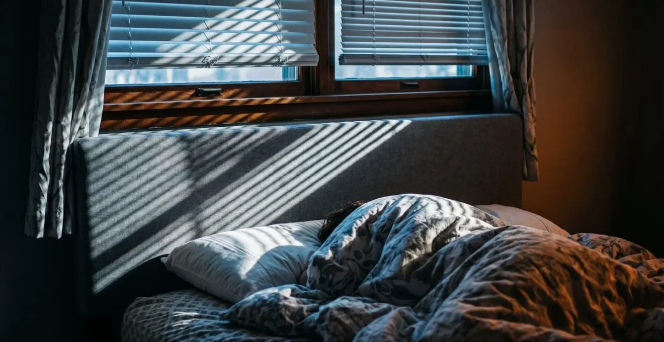 Camera con letto posizionato sotto finestra mostrando problemi di temperatura e luce